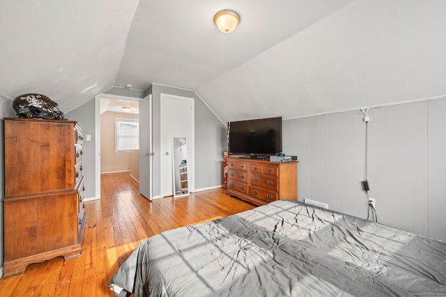 bedroom featuring light wood-type flooring and vaulted ceiling