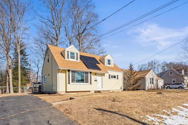 new england style home featuring solar panels