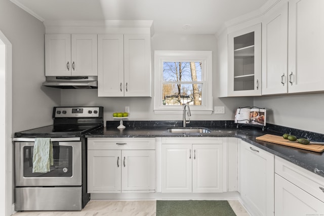 kitchen featuring stainless steel range with electric stovetop, sink, white cabinetry, and dark stone counters