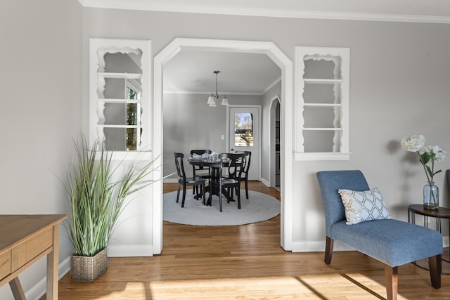 dining area with crown molding, hardwood / wood-style floors, and a chandelier