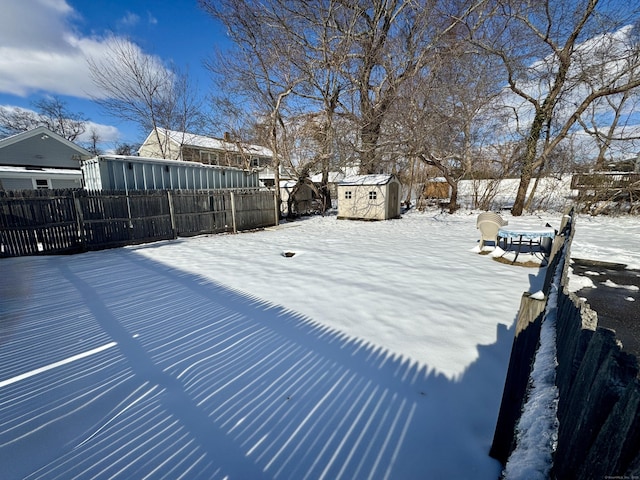 yard covered in snow with a shed