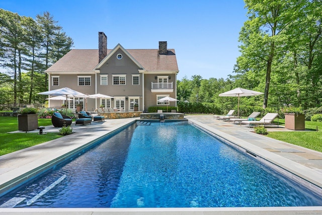 pool featuring an in ground hot tub and a patio area