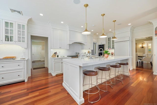 kitchen featuring glass insert cabinets, white cabinetry, a breakfast bar area, and light countertops