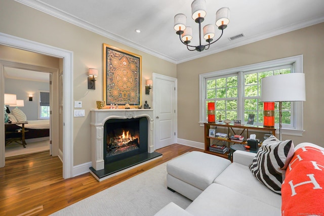 living room featuring a chandelier, visible vents, plenty of natural light, and ornamental molding