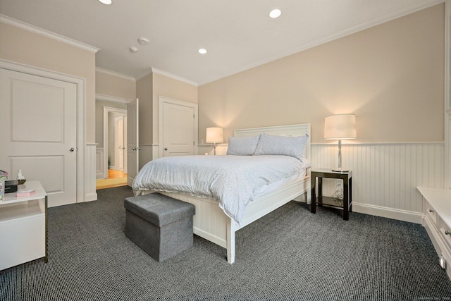 bedroom with recessed lighting, a wainscoted wall, dark carpet, and ornamental molding