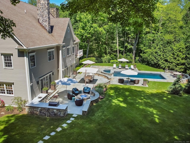 outdoor pool featuring outdoor dining space, a patio, an outdoor fire pit, an in ground hot tub, and a yard