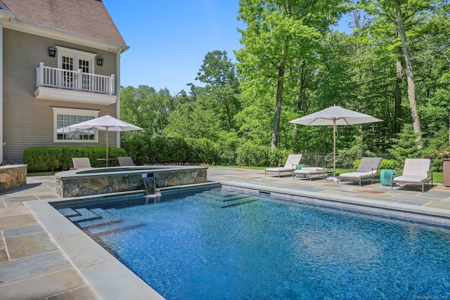 pool featuring a patio area and an in ground hot tub