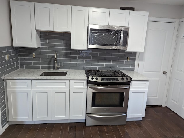 kitchen featuring sink, stainless steel appliances, dark hardwood / wood-style floors, light stone countertops, and white cabinets