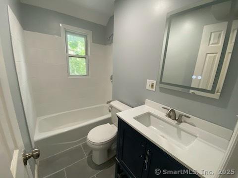 full bathroom featuring bathing tub / shower combination, vanity, tile patterned floors, and toilet