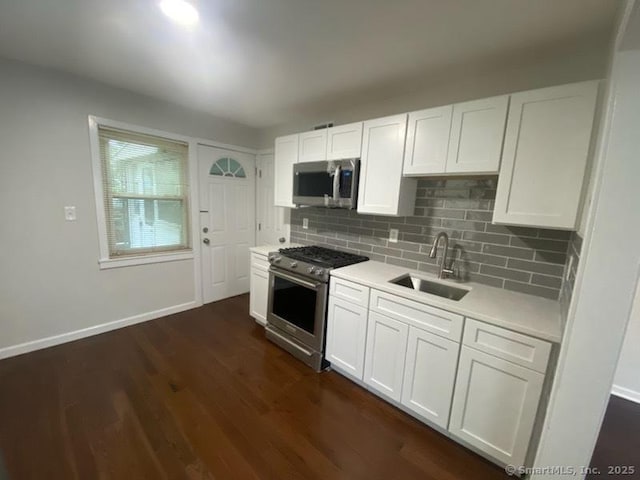 kitchen featuring stainless steel appliances, white cabinetry, sink, and dark wood-type flooring