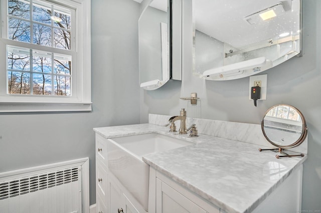 bathroom with vanity, radiator, and a wealth of natural light