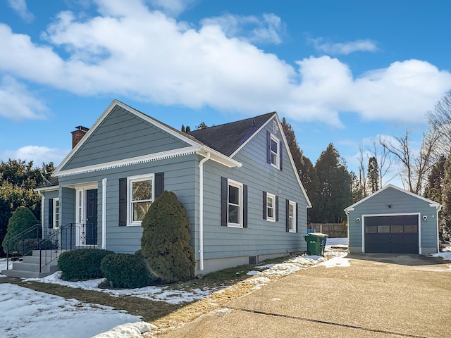 view of snowy exterior featuring a garage and an outdoor structure