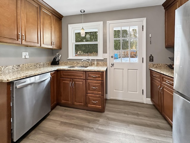 kitchen with pendant lighting, stainless steel appliances, sink, and plenty of natural light