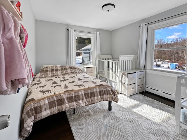 bedroom featuring baseboard heating and light wood-type flooring