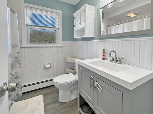 bathroom featuring vanity, hardwood / wood-style flooring, a baseboard radiator, and toilet