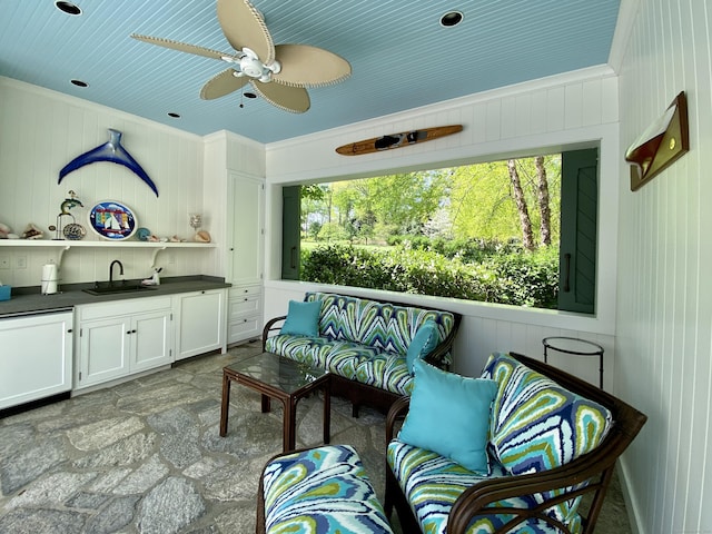 109 Elys Ferry Rd, Lyme, CT 06371 - living area featuring dark stone finish flooring, a ceiling fan, crown molding, and wooden walls
