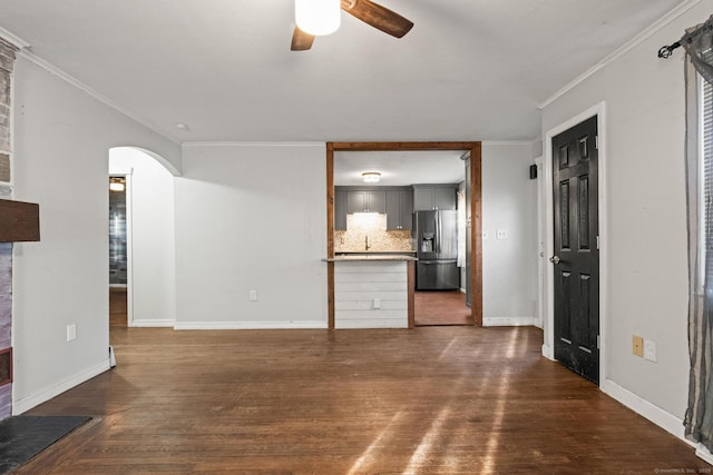 unfurnished living room with ceiling fan, crown molding, and dark hardwood / wood-style flooring