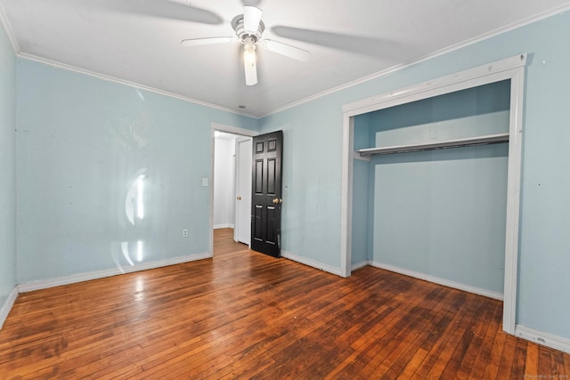 unfurnished bedroom with a closet, crown molding, dark hardwood / wood-style floors, and ceiling fan