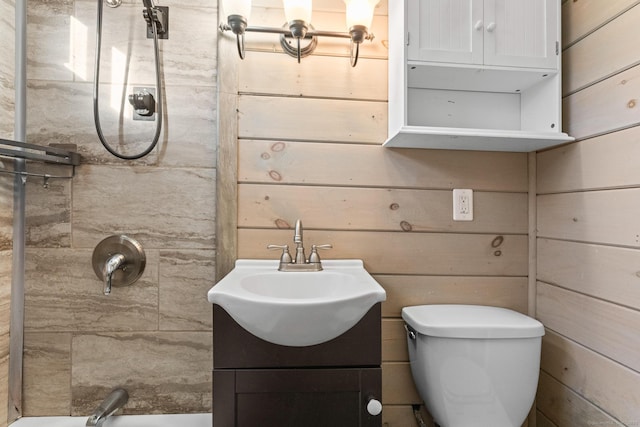 bathroom with vanity, toilet, and a tile shower