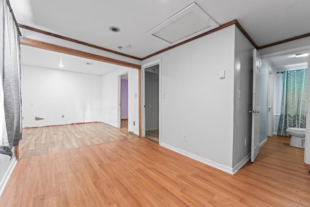 empty room featuring ornamental molding and light wood-type flooring