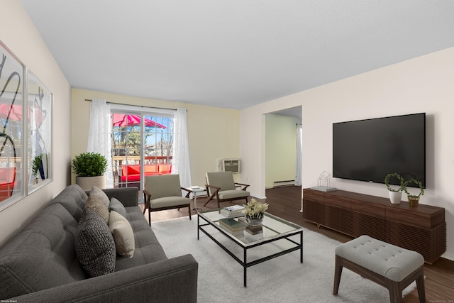 living room featuring a wall mounted AC, light hardwood / wood-style floors, and a baseboard heating unit