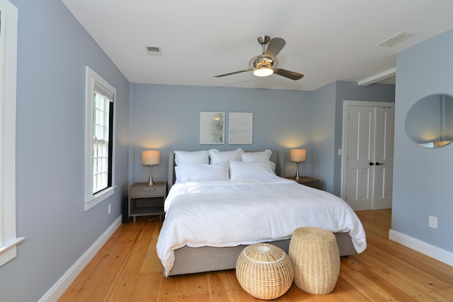 bedroom featuring baseboards, a closet, visible vents, and light wood-style floors