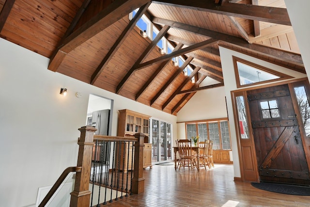 foyer entrance with beamed ceiling, wooden ceiling, high vaulted ceiling, and light wood-type flooring