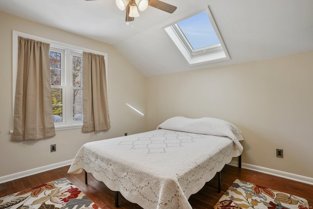 bedroom with hardwood / wood-style flooring, ceiling fan, and vaulted ceiling with skylight