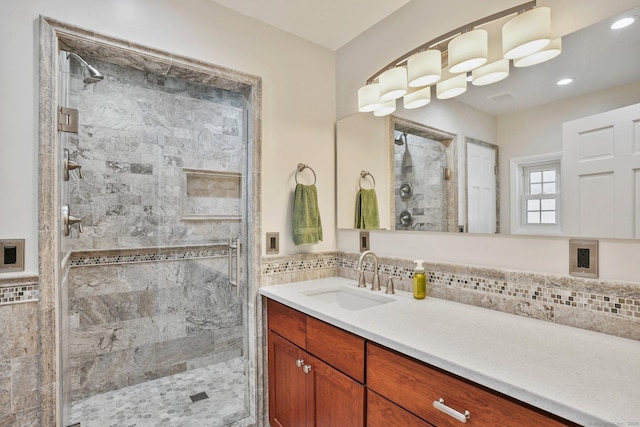 bathroom with vanity, decorative backsplash, and walk in shower