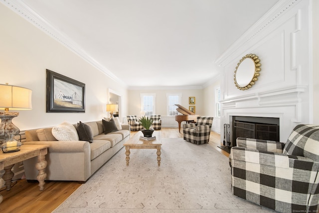 living area with light wood-type flooring, a fireplace, and crown molding