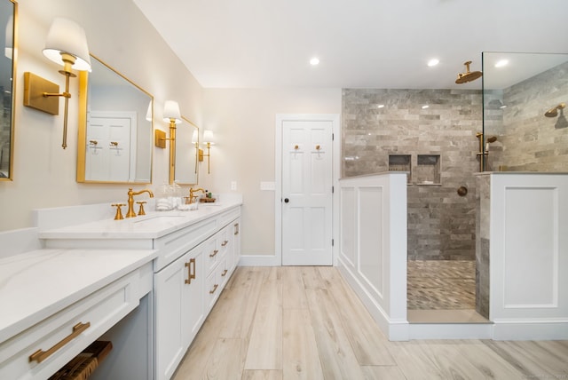 bathroom with recessed lighting, walk in shower, wood finished floors, and vanity