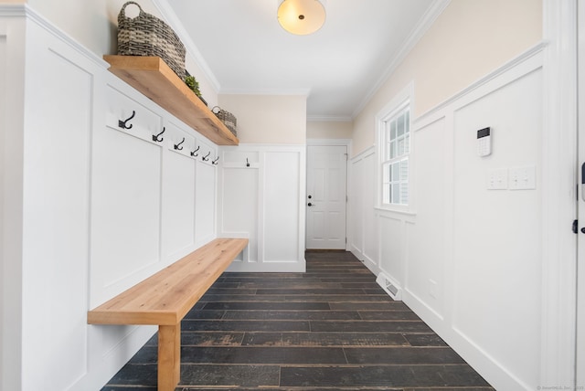 mudroom with a decorative wall, dark wood-style flooring, visible vents, and crown molding