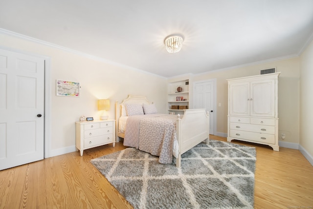 bedroom with ornamental molding, baseboards, visible vents, and light wood finished floors