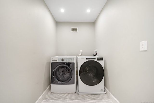 laundry area with laundry area, separate washer and dryer, visible vents, and baseboards