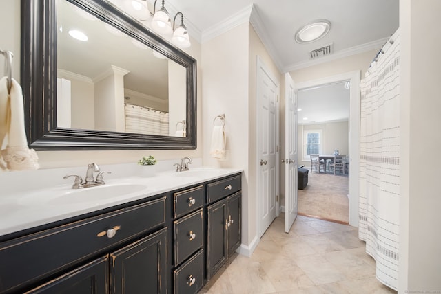 ensuite bathroom with ornamental molding, visible vents, and a sink