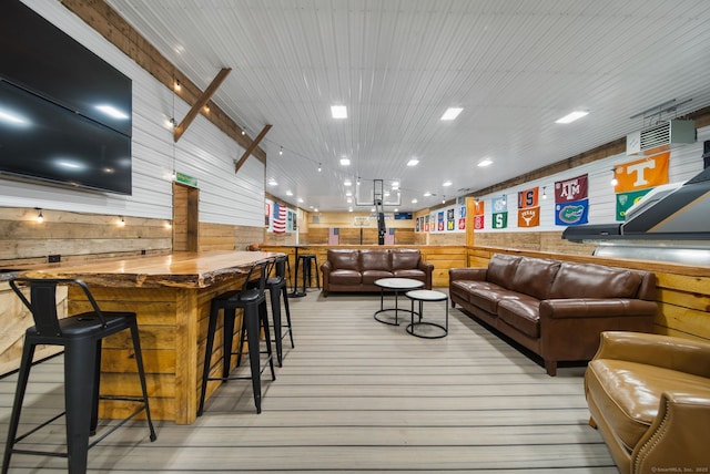 living area with light wood-style floors and wood walls