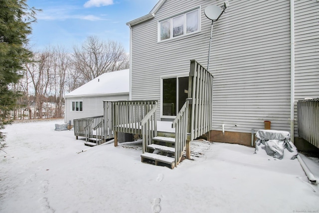 snow covered rear of property with a wooden deck