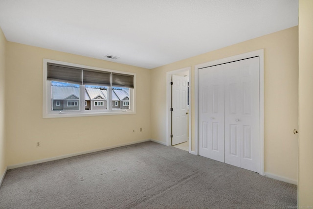 unfurnished bedroom featuring a closet and light carpet