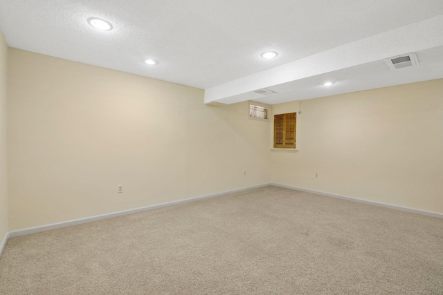 basement featuring a textured ceiling and carpet