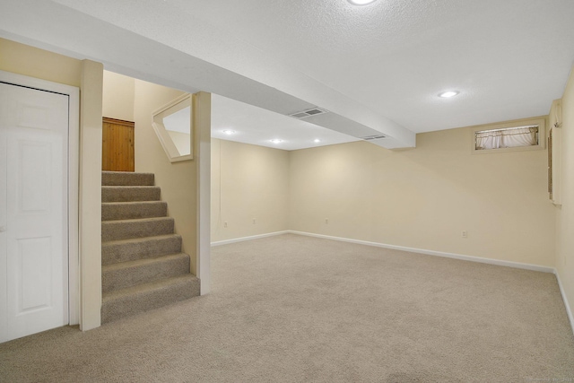 basement with carpet flooring and a textured ceiling