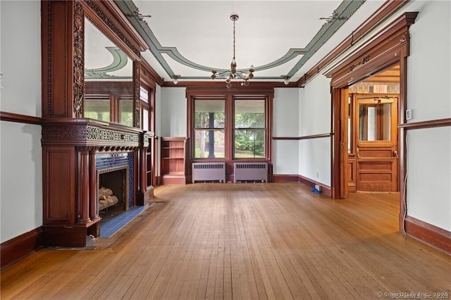 unfurnished room with radiator, crown molding, and light wood-type flooring