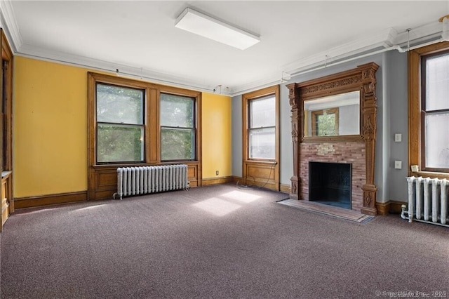 unfurnished living room featuring ornamental molding, carpet flooring, radiator, and a brick fireplace