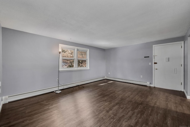 spare room featuring dark hardwood / wood-style flooring and a baseboard radiator