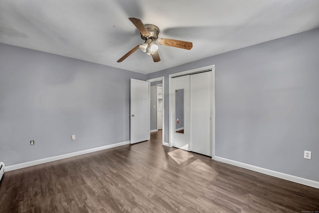 unfurnished bedroom with hardwood / wood-style flooring, baseboard heating, ceiling fan, and a closet