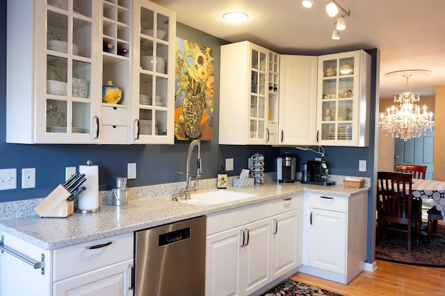 kitchen with white cabinetry, sink, stainless steel dishwasher, and light stone counters