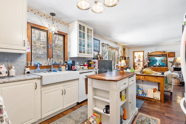 kitchen featuring a healthy amount of sunlight, decorative light fixtures, dishwasher, and sink