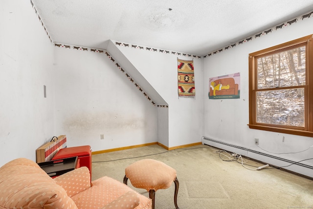 interior space featuring a baseboard heating unit, a textured ceiling, and carpet flooring