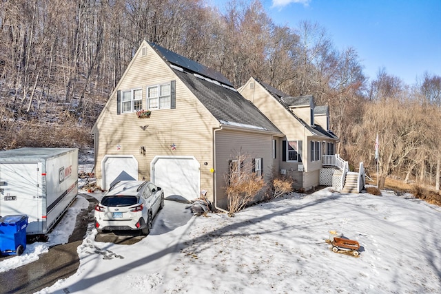 snow covered property with a garage