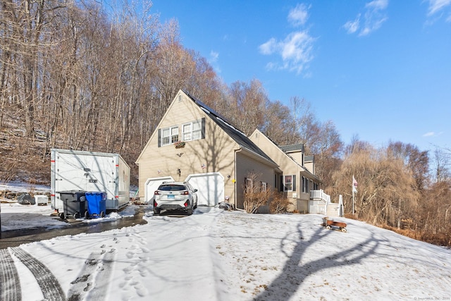 snow covered property with a garage