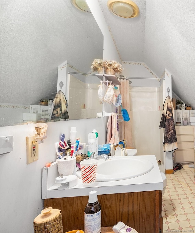 bathroom with lofted ceiling, vanity, a textured ceiling, and a shower with shower curtain